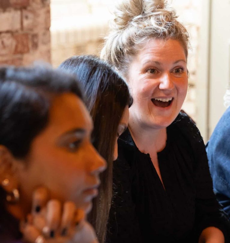 A close up of a woman laughing about something.