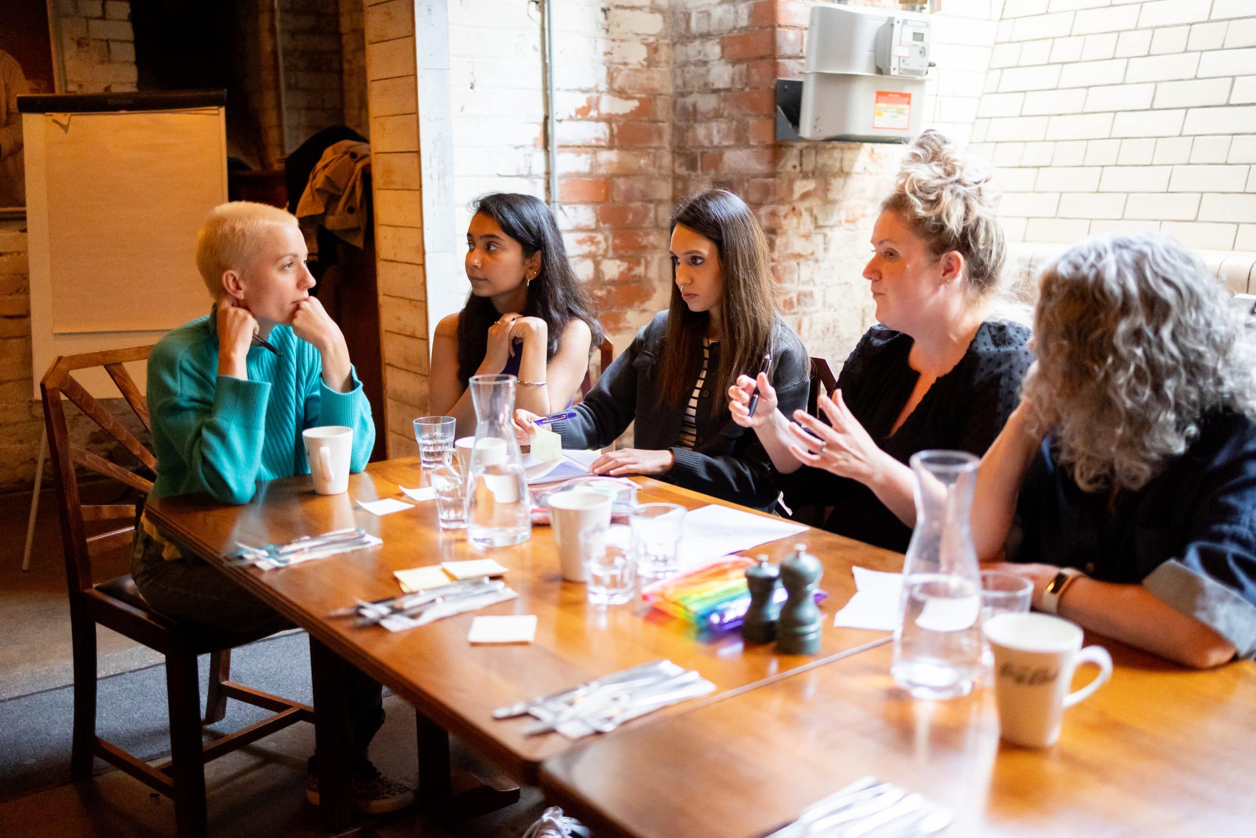 A group of people discussing something around a table.